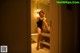 A woman sitting on a toilet in a bathroom.
