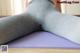 A woman is sitting on a yoga mat with her back to the camera.