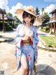 A woman in a blue kimono and a straw hat.