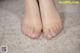 A close up of a person's bare feet on a carpet.