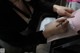 A woman sitting at a table writing on a piece of paper.