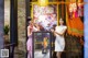 A couple of women standing next to each other in front of a store.